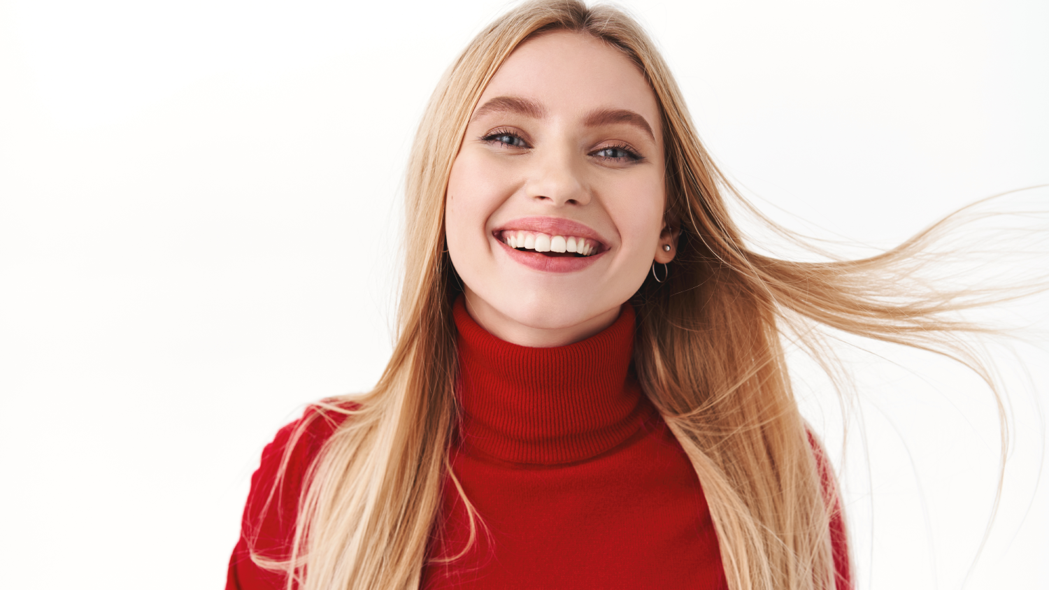 A smiling patient with perfect white teeth sits in a modern Turkish dental clinic chair